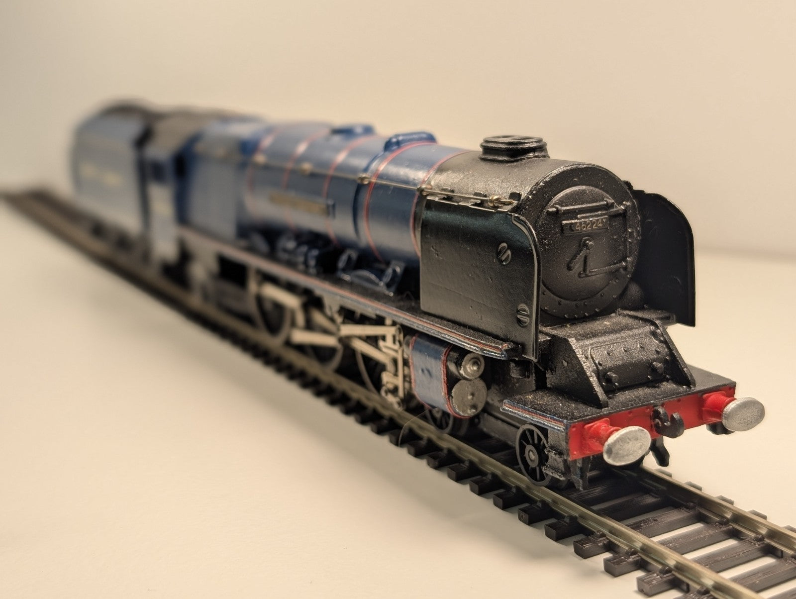 Blue and black model train on tracks