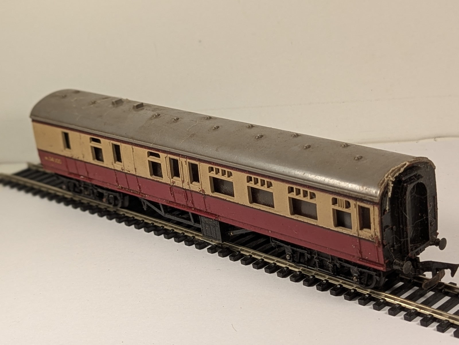 Tri-ang OO gauge BR crimson and cream composite passenger coach on model railway track