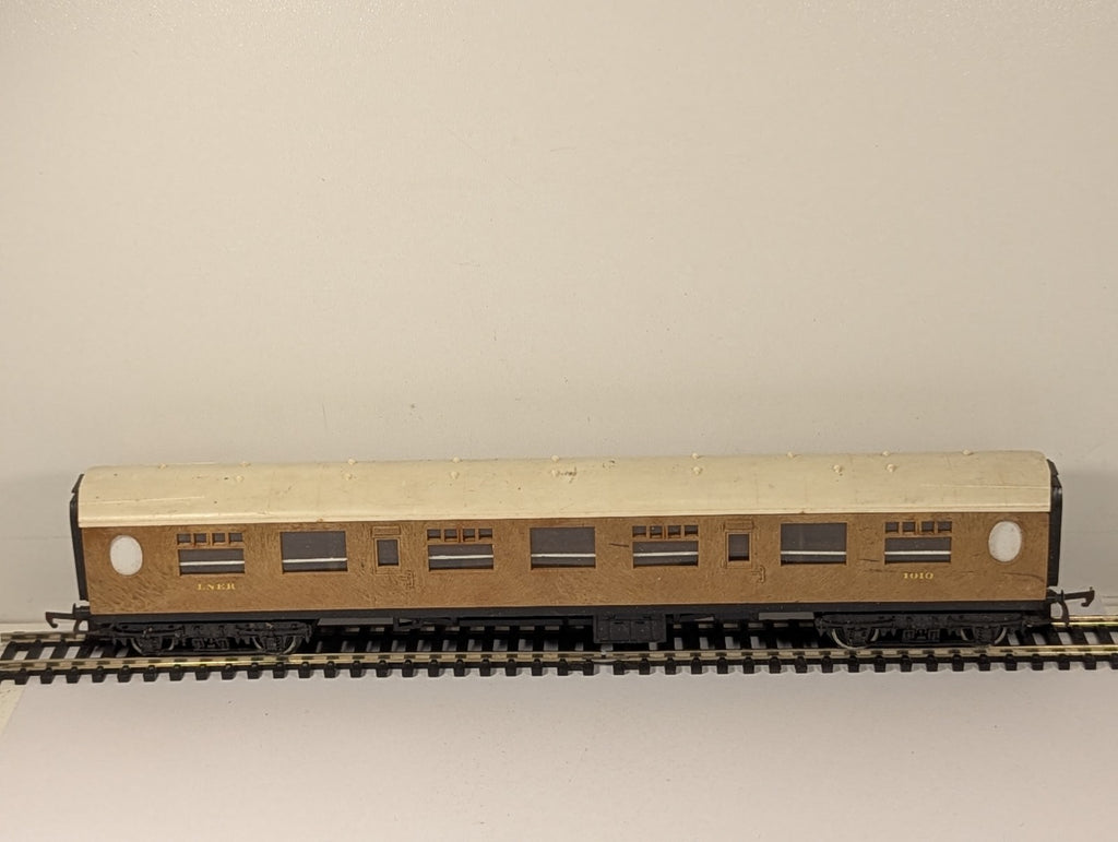 Tri-ang OO Gauge LNER composite passenger coach 1010 with teak finish on model railway track