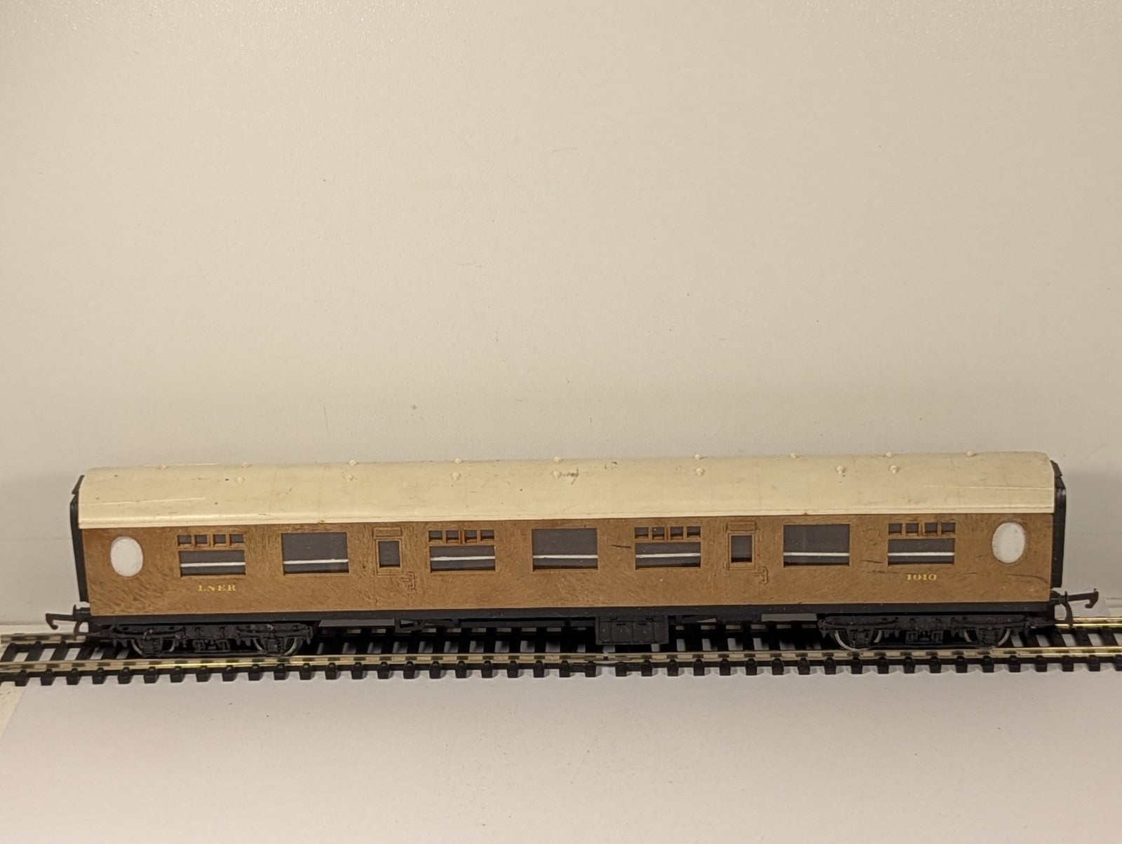 Tri-ang OO Gauge LNER composite passenger coach 1010 with teak finish on model railway track