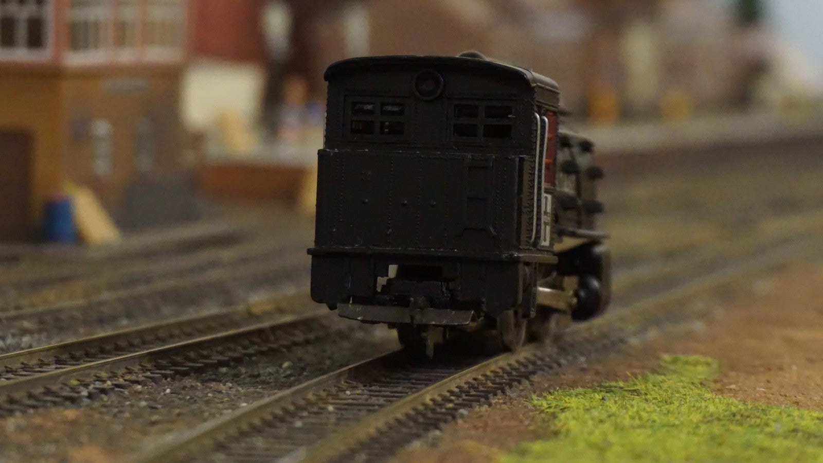 Rear view of Life-Like HO scale black steam locomotive on model train tracks